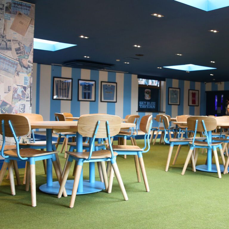 A room with sky blue striped walls and tables